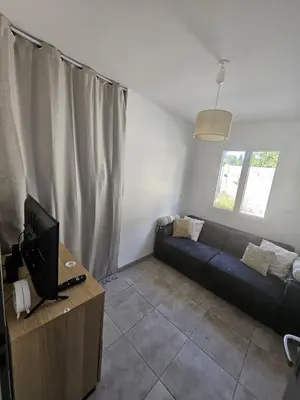 a living room with a couch and a television at Villa Eguilles, ensoleillée, piscine à 10 mn d' Aix en Provence in Éguilles