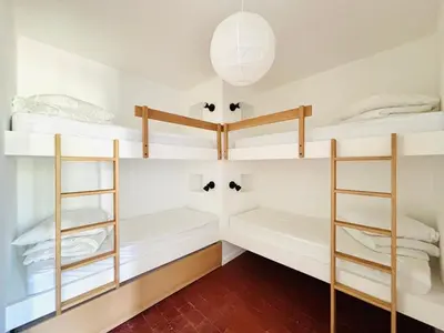 a room with three bunk beds with white walls at Maison Poumo, Piscine, clim & padel privé,12 pers in LʼIsle-sur-la-Sorgue