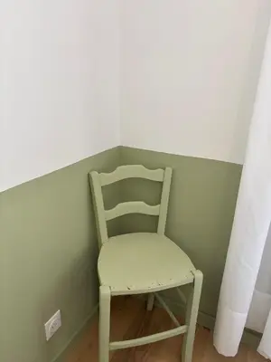 a chair sitting in a corner of a room at Maison Poumo, Piscine, clim & padel privé,12 pers in LʼIsle-sur-la-Sorgue