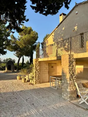 a building with a balcony on the side of it at Maison Poumo, Piscine, clim & padel privé,12 pers in LʼIsle-sur-la-Sorgue