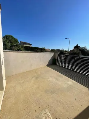 a empty parking lot next to a wall at Maison climatisée avec jardin in Caumont-sur-Durance