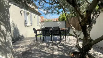 a table and chairs on a patio with a tree at Maison climatisée avec jardin in Caumont-sur-Durance