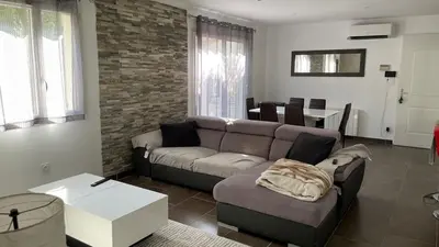 a living room with a couch and a table at Maison climatisée avec jardin in Caumont-sur-Durance