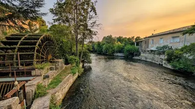 a river in a town with houses and trees at Cosy & Cocooning in Le Thor