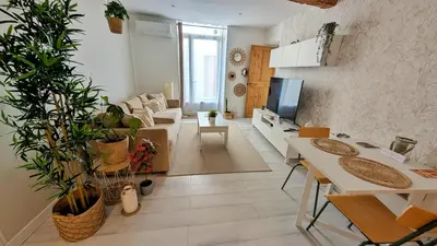 a living room with a couch and a table with plants at Cosy & Cocooning in Le Thor