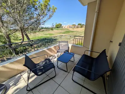 a balcony with chairs and a view of a field at Golf apartment in Saumane-de-Vaucluse