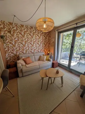 a living room with a couch and a table at Golf apartment in Saumane-de-Vaucluse