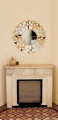 a mirror over a fireplace in a living room at Appartement avec extérieur in LʼIsle-sur-la-Sorgue