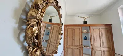 a mirror on a wall next to a cabinet at Appartement avec extérieur in LʼIsle-sur-la-Sorgue