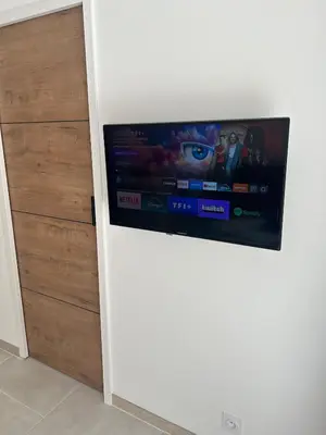 a flat screen tv on a wall next to a door at Suite jacuzzi in Aix-en-Provence