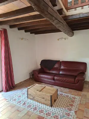 a living room with a brown leather couch and a coffee table at Cabanon provençal en pierre entouré de lavandes in Vachères