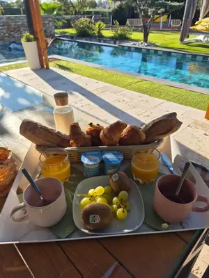 a tray of breakfast food on a table next to a pool at Ô nuits de saint cannat in Saint-Cannat