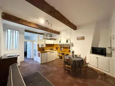 a kitchen and dining room with a table and a television at Le Manuel - Appart T2 cosy Centre ville historique - Place des Prêcheurs Palais de justice in Aix-en-Provence