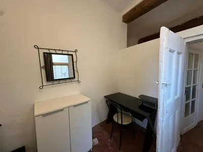 a small room with a table and a mirror at Le Manuel - Appart T2 cosy Centre ville historique - Place des Prêcheurs Palais de justice in Aix-en-Provence