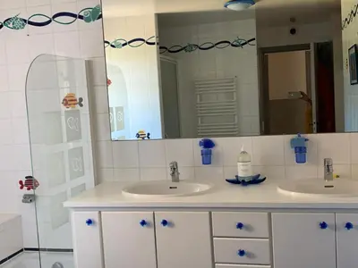 a bathroom with two sinks and a mirror at La bergerie in Cadenet