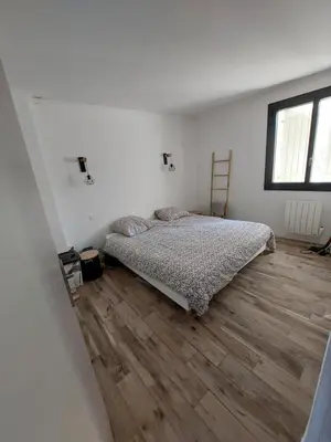a bedroom with a bed and a wooden floor at Mas Saint André 3 étoiles au cœur de la Provence in Saint-Andiol