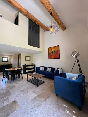 a living room with a blue couch and a table at Mas Saint André 3 étoiles au cœur de la Provence in Saint-Andiol