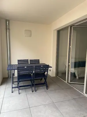 a blue table and two chairs in a room at Le Triton, new appartments near city center , parking , lift in Aix-en-Provence
