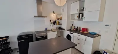 a kitchen with white cabinets and a black counter top at Le Triton, new appartments near city center , parking , lift in Aix-en-Provence