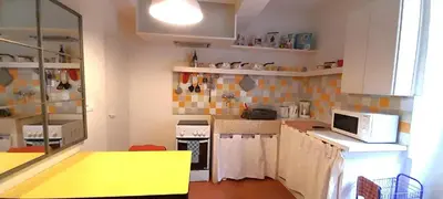 a kitchen with white cabinets and a yellow counter top at La Cachette centre historique village in Roussillon