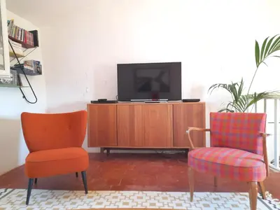 a living room with two chairs and a television at La Cachette centre historique village in Roussillon
