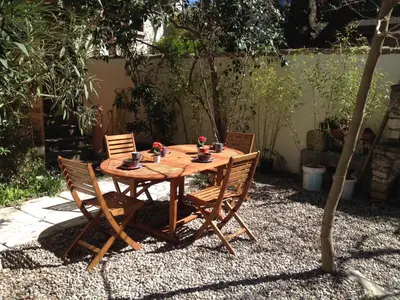 a wooden table and chairs in a garden at La casa du Roy René in Aix-en-Provence