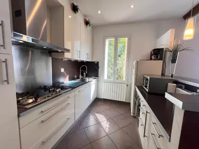 a kitchen with white cabinets and a white refrigerator at La casa du Roy René in Aix-en-Provence