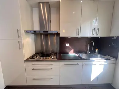 a kitchen with white cabinets and a stove and a sink at La casa du Roy René in Aix-en-Provence