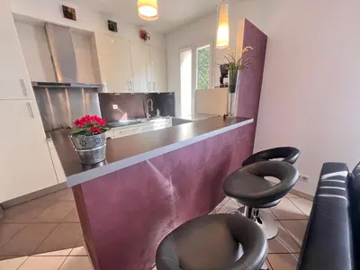 a kitchen with a counter and two stools at La casa du Roy René in Aix-en-Provence