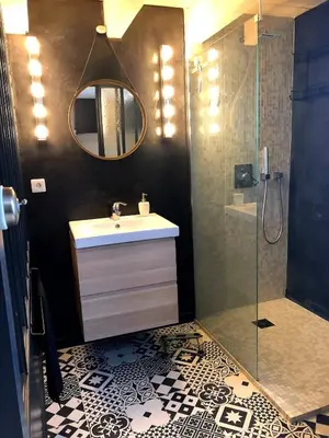 a bathroom with a sink and a shower with a mirror at Le colibri du Luberon in Apt