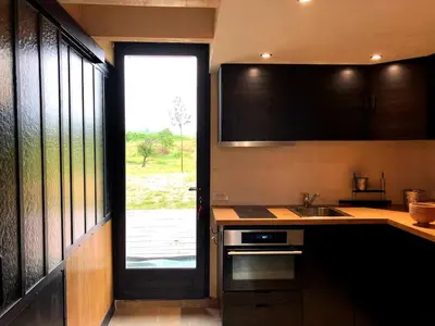 a kitchen with a door and a sink and a window at Le colibri du Luberon in Apt