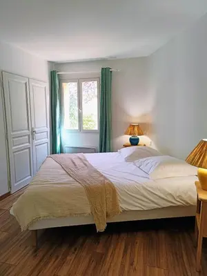 a bedroom with a large bed and a window at Au coeur des ocres in Roussillon