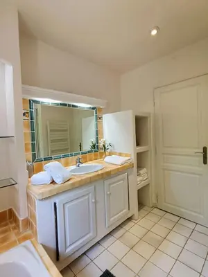 a bathroom with a sink and a mirror at Au coeur des ocres in Roussillon