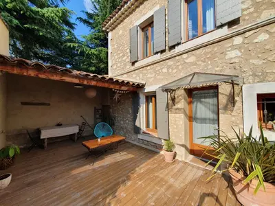 a patio of a house with a wooden deck at Le nid douillet in Pertuis
