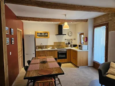 a kitchen with a wooden table and a dining room at Le nid douillet in Pertuis
