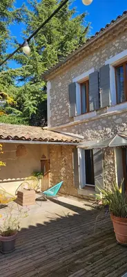 a house with a hammock in front of it at Le nid douillet in Pertuis