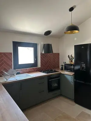 a kitchen with a stove and a black refrigerator at Le Fort 6 - Appartement neuf 6p in LʼIsle-sur-la-Sorgue