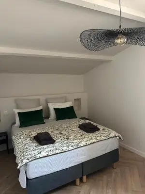 a bedroom with a large bed with green pillows at Le Fort 6 - Appartement neuf 6p in LʼIsle-sur-la-Sorgue