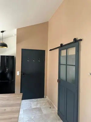 a room with two black doors in a room at Le Fort 6 - Appartement neuf 6p in LʼIsle-sur-la-Sorgue