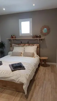 a bedroom with a large bed with a window and a table at Maison Luberon piscine in Viens