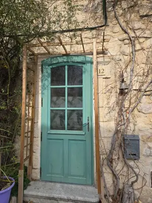 a green door on a stone building with a window at Appartement Gîte d'Etape Vitrolles en Luberon in Vitrolles-en-Luberon