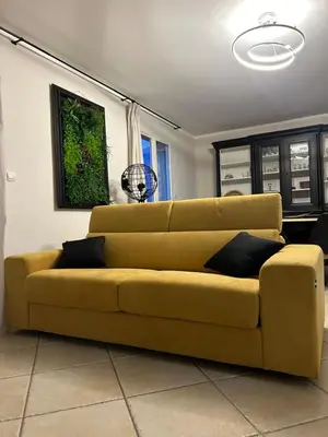 a yellow couch sitting in a living room at Maison Hélène Piano in La Tour-dʼAigues