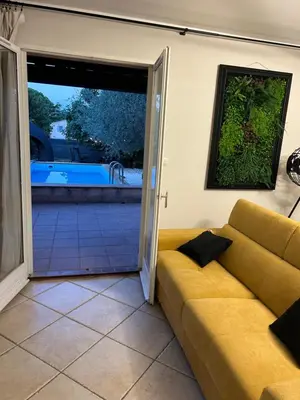 a living room with a couch and a sliding glass door at Maison Hélène Piano in La Tour-dʼAigues