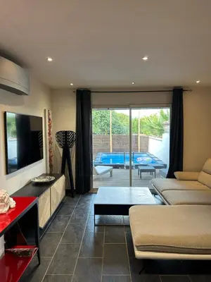 a living room with a couch and a tv at Maison Hélène Piano in La Tour-dʼAigues