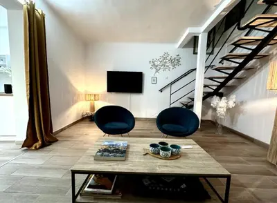 a living room with two chairs and a table at T2 à 5mn à pieds du Cours Mirabeau in Aix-en-Provence