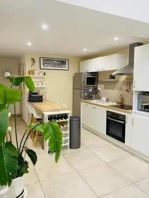 a kitchen with white appliances and a plant in a room at Tiny House - Les Baïsses - Jardin Tropical in Lançon-Provence