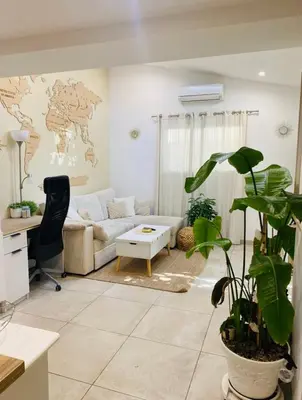 a living room with a couch and a table at Tiny House - Les Baïsses - Jardin Tropical in Lançon-Provence