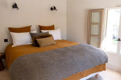 a bedroom with a large bed with pillows and a window at Villa entièrement rénovée in Saint-Rémy-de-Provence