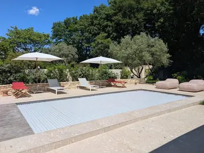 a swimming pool with two chairs and umbrellas at Villa entièrement rénovée in Saint-Rémy-de-Provence