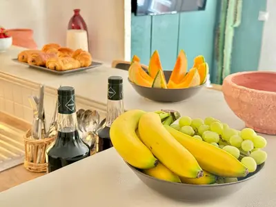 a bowl of bananas and grapes on a counter at Refuge reposant - Centre ville - Espace Bureau in Aix-en-Provence